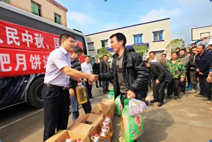 公司紀(jì)委書記陳大業(yè)（左）向鐵礦鄉(xiāng)幸福村貧困戶發(fā)放慰問(wèn)物資