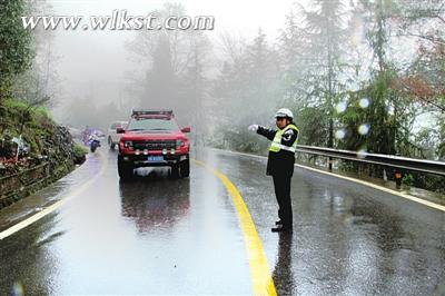 圖為羅旦華冒雨為過往車輛導航。