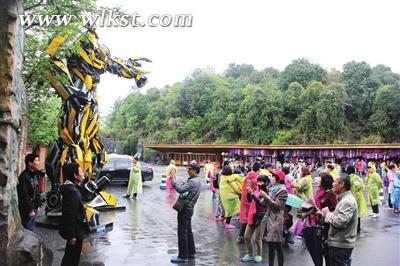 圖為游客在天生三橋入口處的“大黃蜂”前留影。