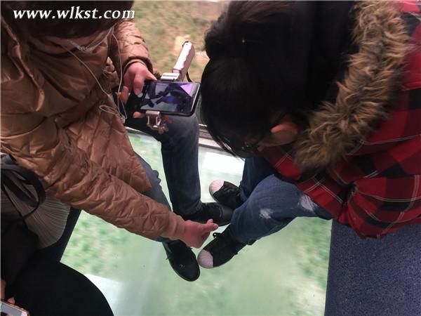 在玻璃廂底的索道內游客俯拍